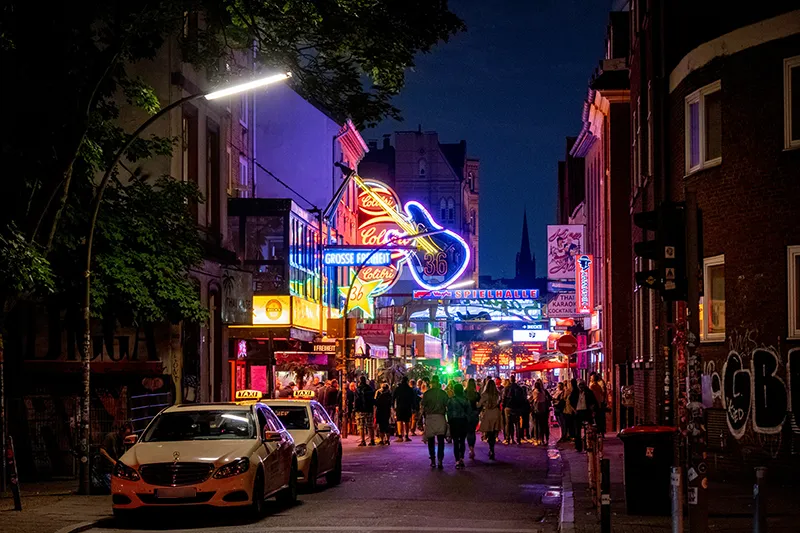 Lively Reeperbahn in Hamburg at night with colourful neon signs