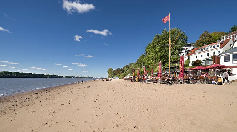 Sandstrand an der Elbe mit Außengastronomie am Ufer