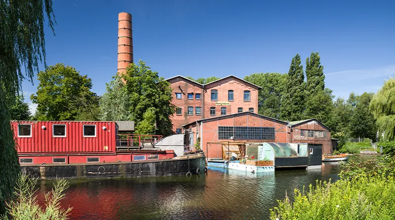 Historische Backsteingebäude und Boote am Wasser in Hamburg-Wilhelmsburg